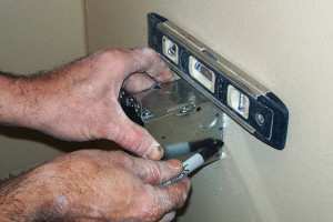 Sostenga la caja eléctrica contra la tablarroca con un nivel encima