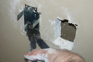  Sin soltar los alicates, empuje el sujetador dentro de la caja eléctrica