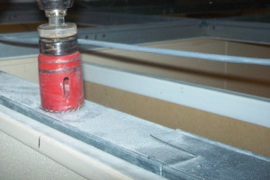 Abra con una sierra perforadora un orificio a través del riel superior